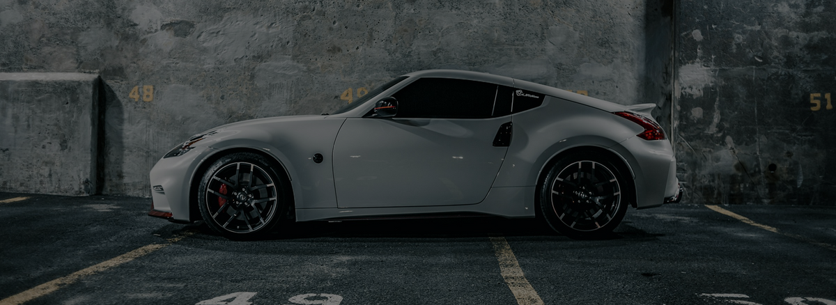 Silver nissan 370z sports car with black alloy wheels and red brake calipers