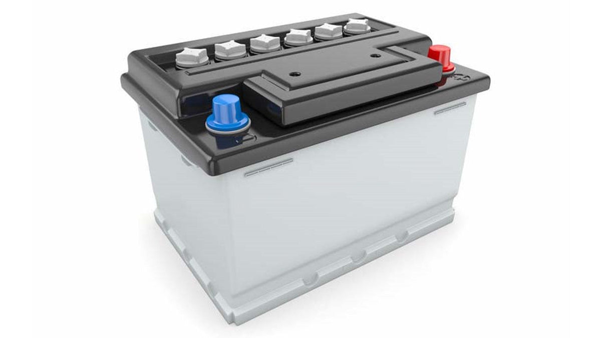 Black and gray car battery with blue and red terminal caps featured in the best battery chargers for indian riders article