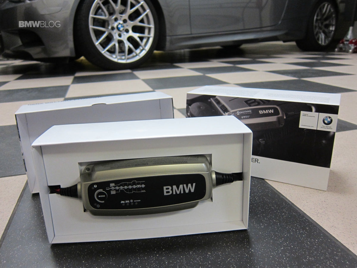 Bmw branded silver and black car battery charger in white packaging for premium car owners in india.