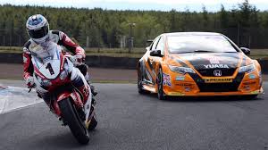 Orange and black race car with sponsor decals illustrating motorbike battery vs car battery differences in 12v battery guide