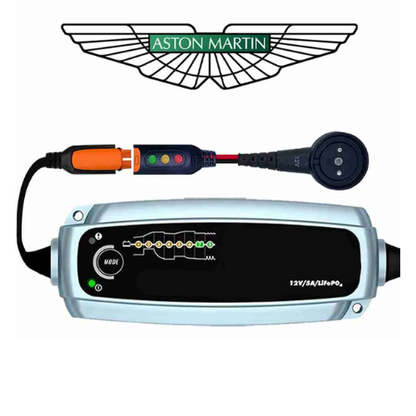 Aston Martin branded automotive electrical testing device with a black front panel, silver casing, orange connector, and attached probe on a white background.