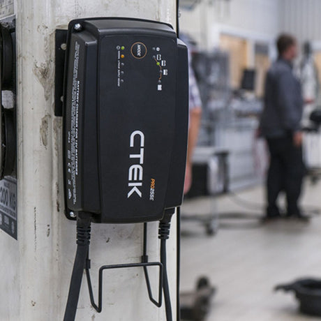 Black CTEK Pro 25S 12V 25A battery charger with sleek rectangular design and indicator lights for workshop fleet charging
