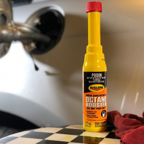 Yellow bottle of rislone super concentrated octane booster with red cap and black label stops engine knock and boosts petrol quality